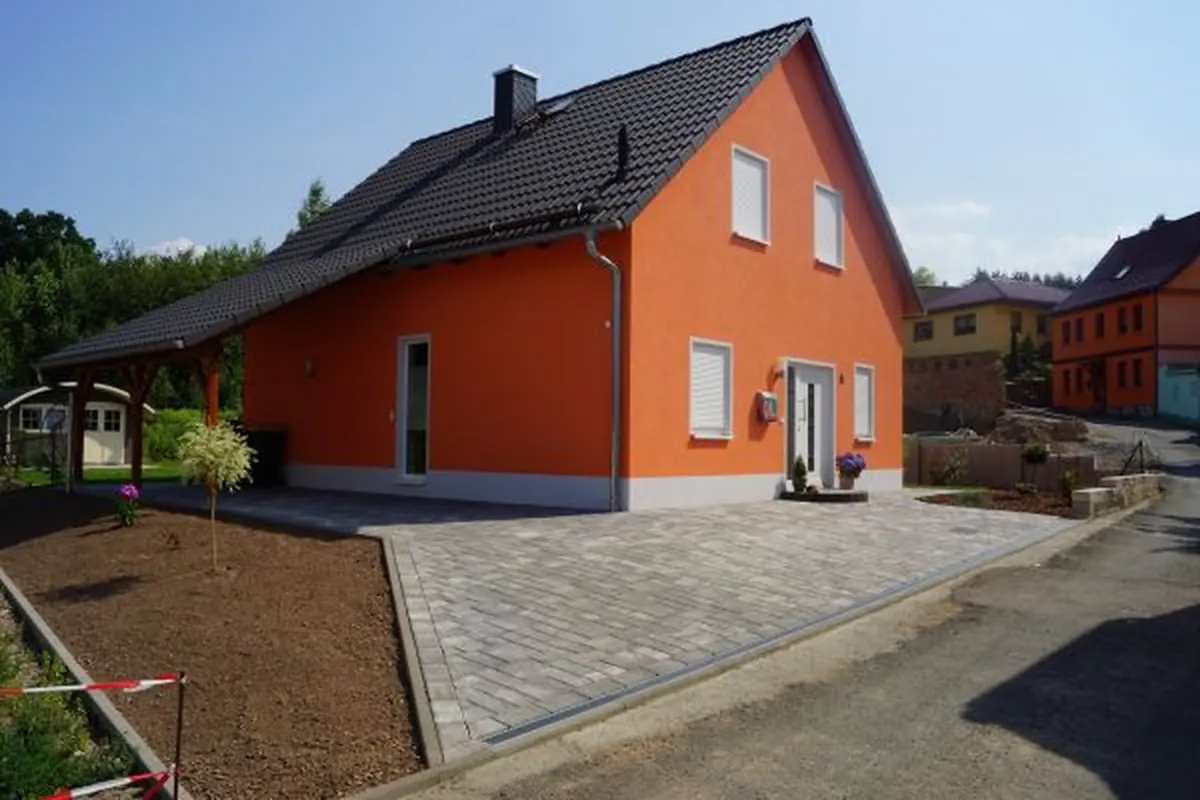 Einfamilienhaus mit oranger Fassade und Carport
