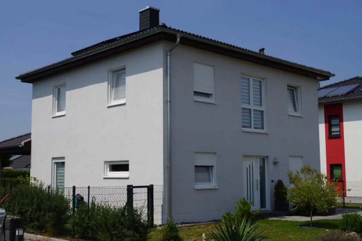 Einfamilienhaus mit grauer Fassade und rotem Akzent